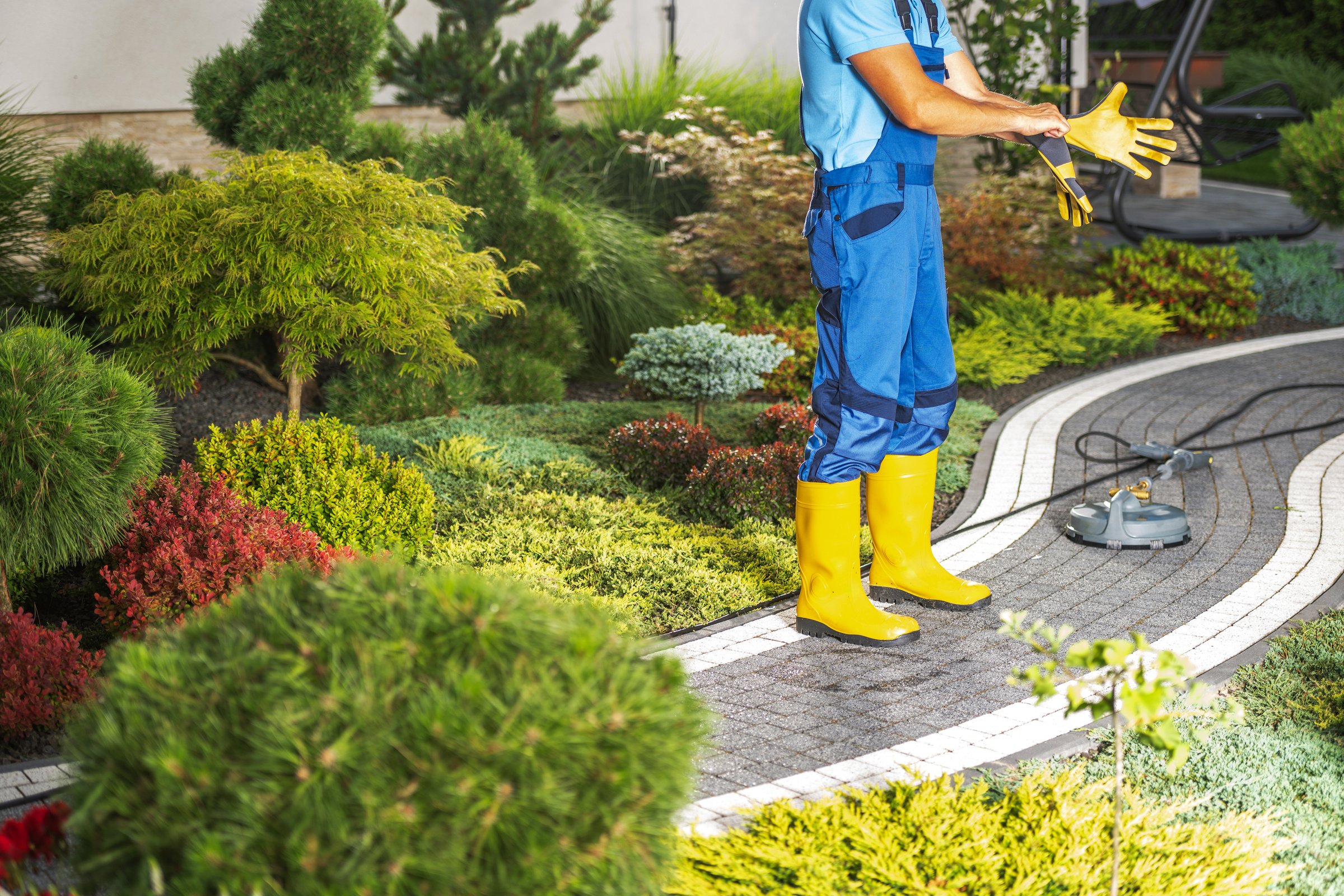 Backyard Brick Paths Pressure Washing Performed by a Worker